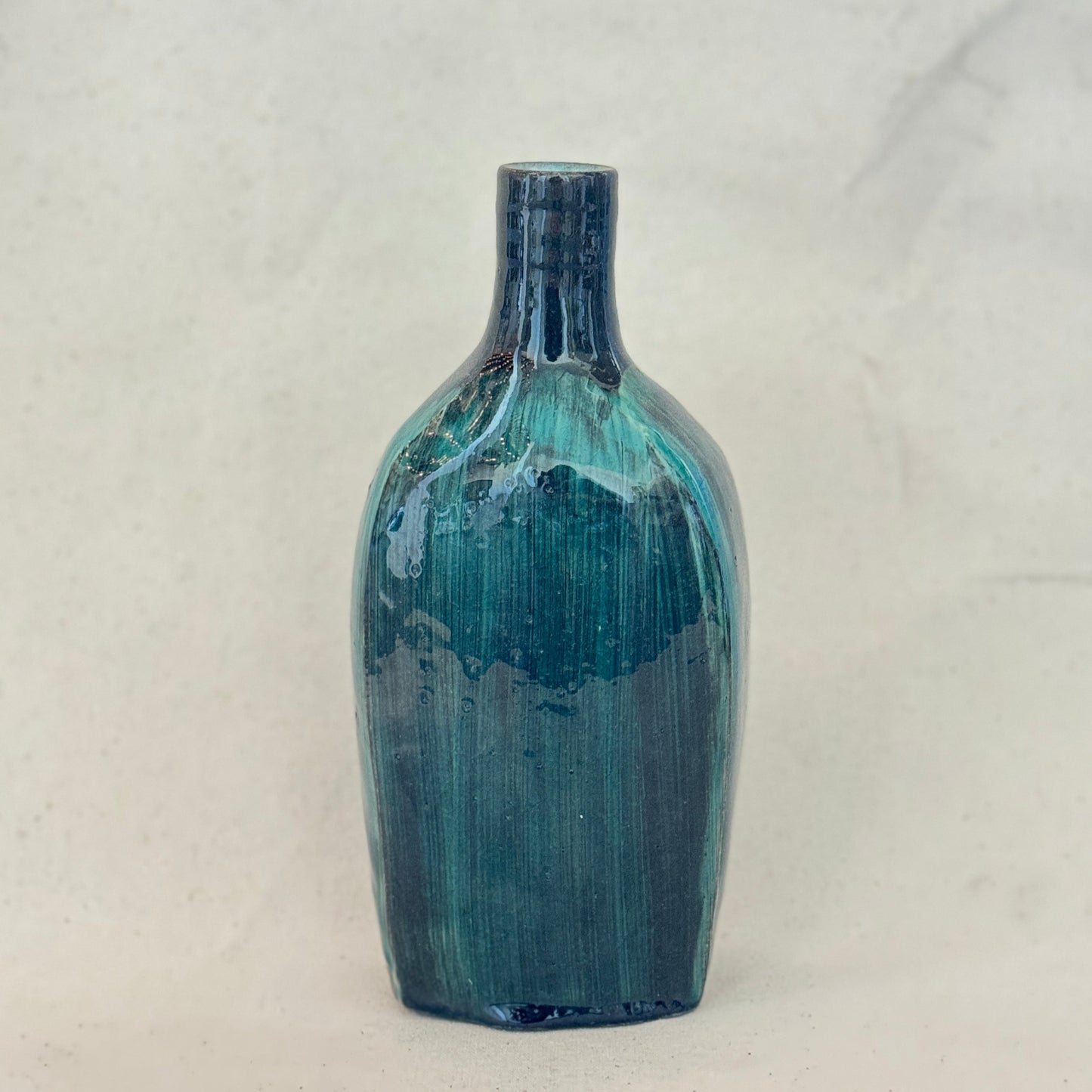 Blue ceramic bottle on a light gray background
