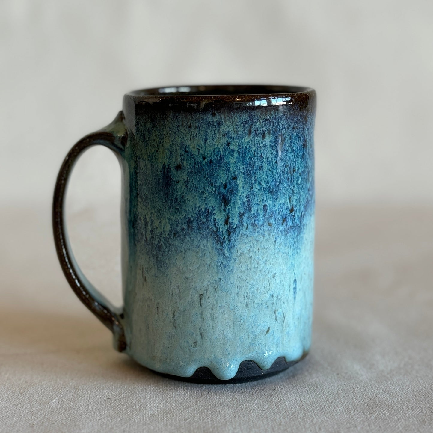 Ceramic mug with blue gradient on a light gray background