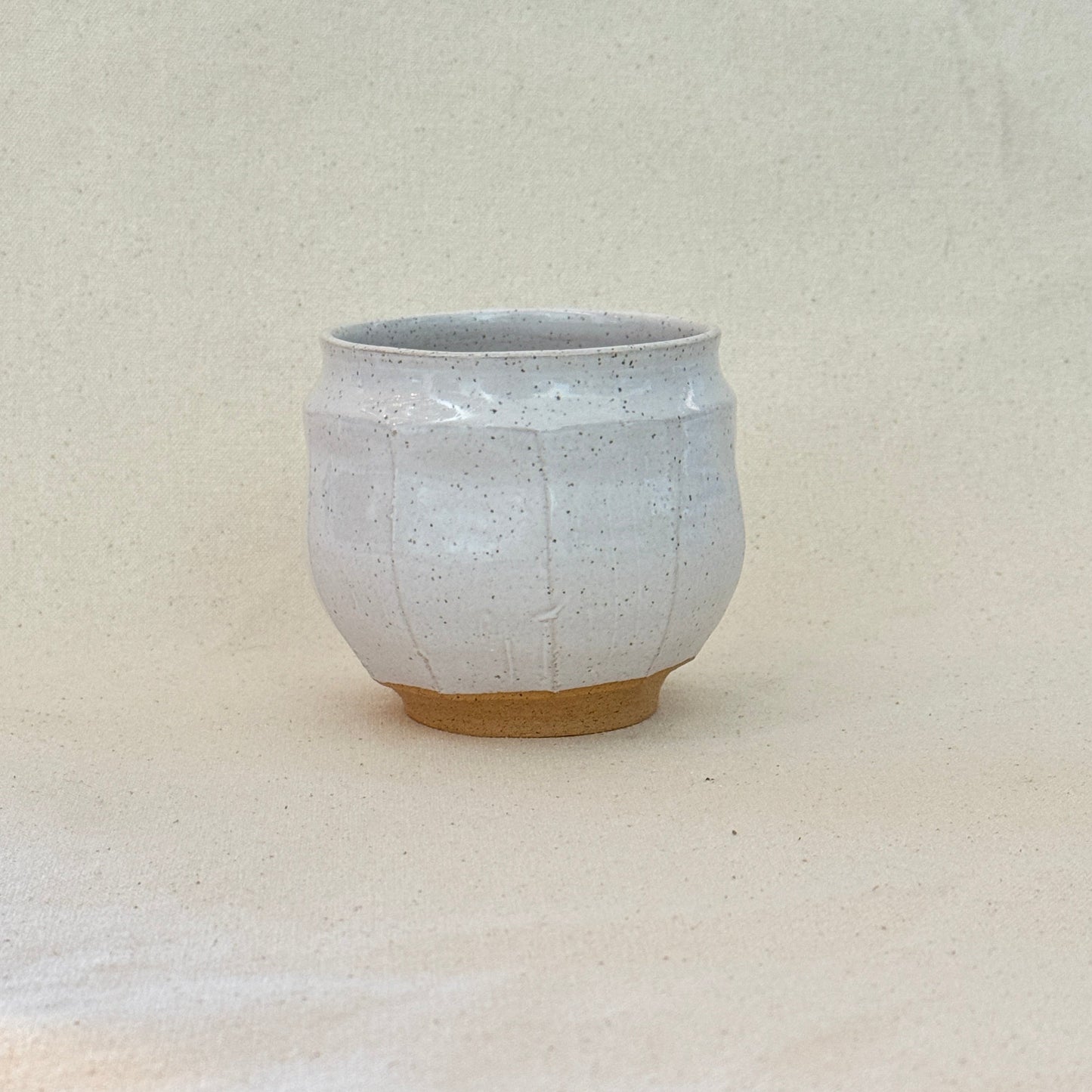Small white ceramic bowl on a textured surface