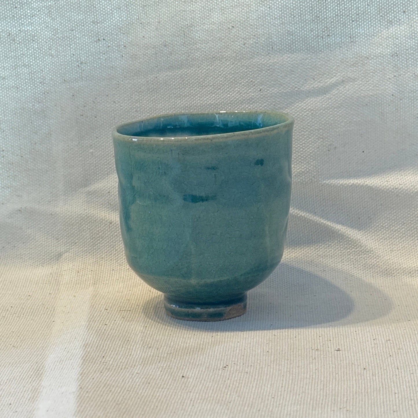 Blue ceramic cup on a light fabric background