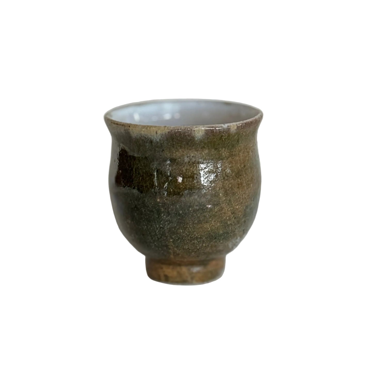Small ceramic cup with a textured surface on a white fabric background