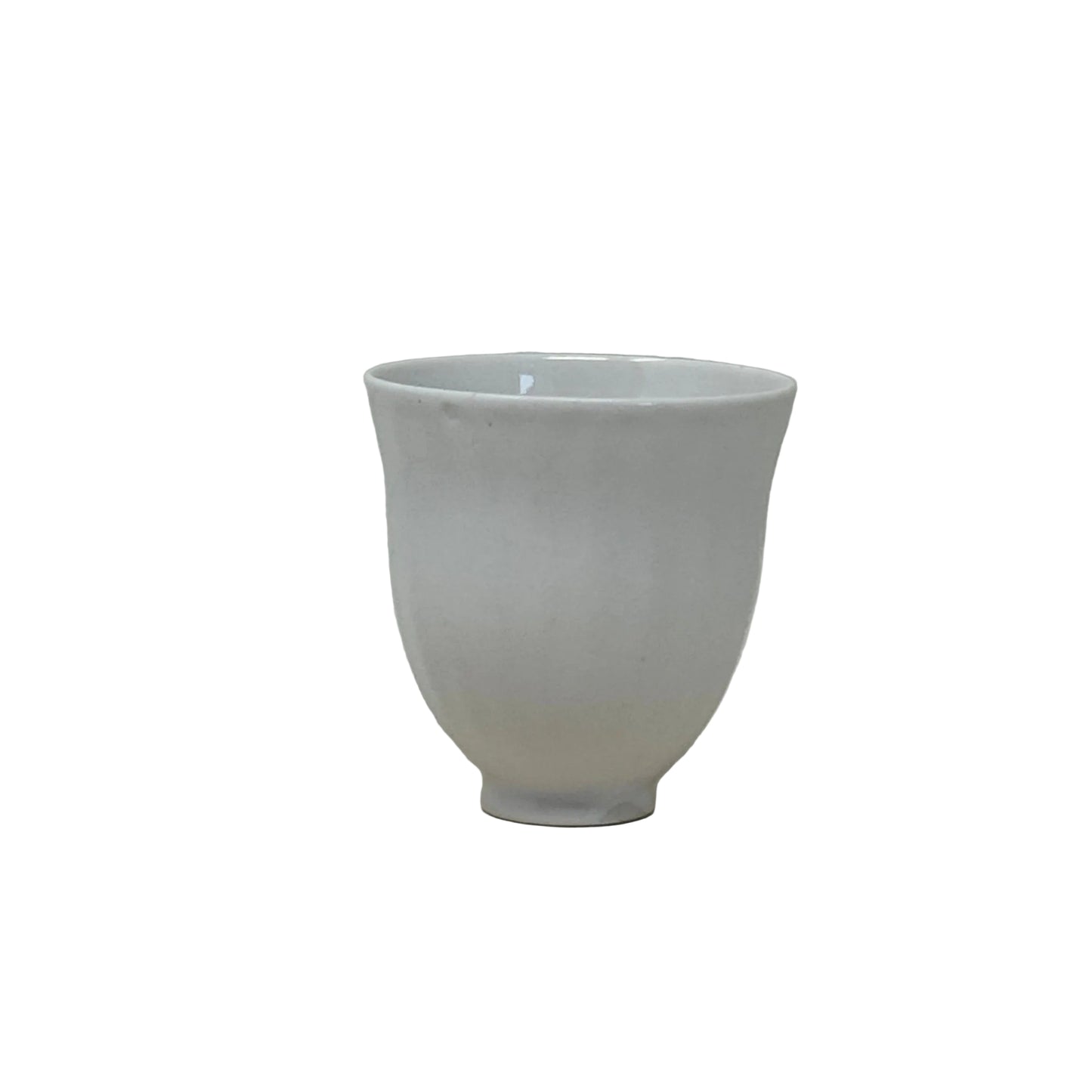White ceramic tea cup on a textured white surface