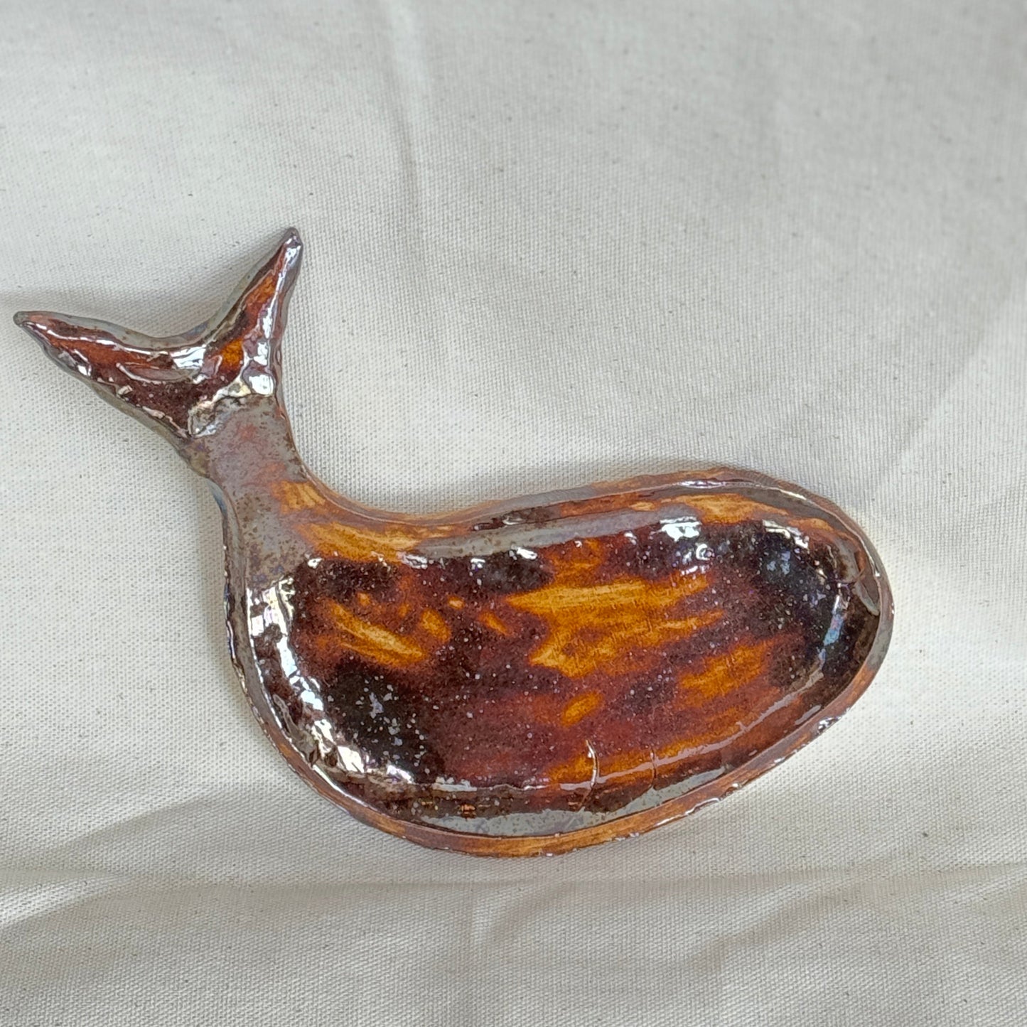 Decorative fish-shaped spoon rest on a light gray background