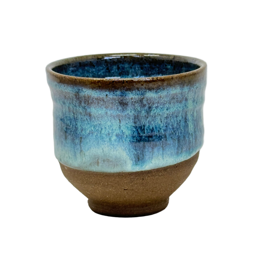 Ceramic cup with blue and brown glaze on a white background