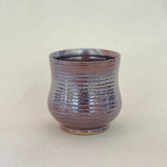 Ceramic cup with textured surface on a plain background