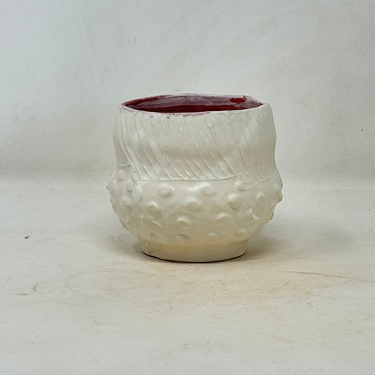 Ceramic white cup with textured surface on a light gray background