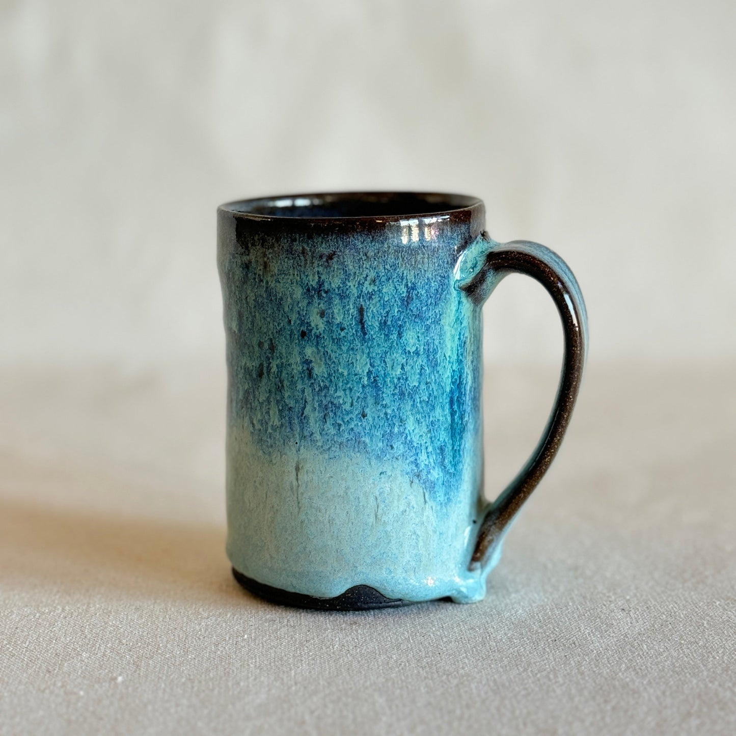 Ceramic mug with blue gradient on a light gray background