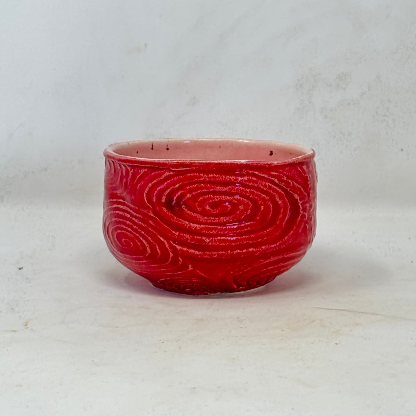 Red bowl with a spiral pattern on a white background