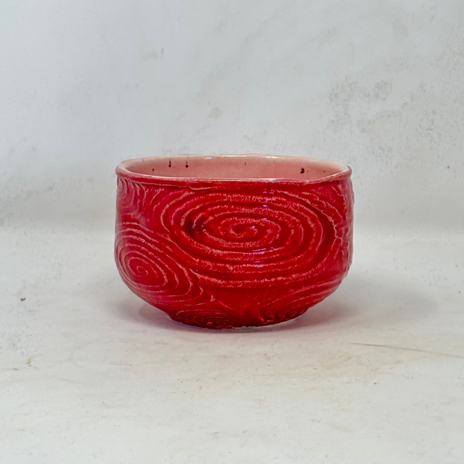 Red bowl with a spiral pattern on a white background