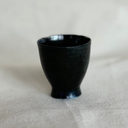 Black ceramic cup on a light fabric background