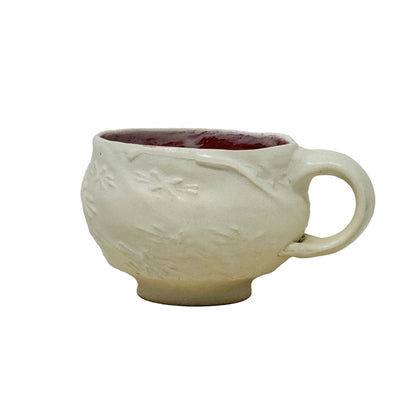 Small ceramic cup with handle on a white background