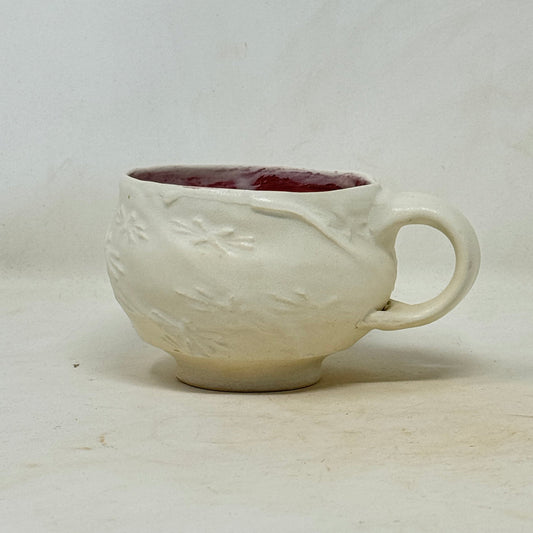 Small ceramic cup with handle on a white background