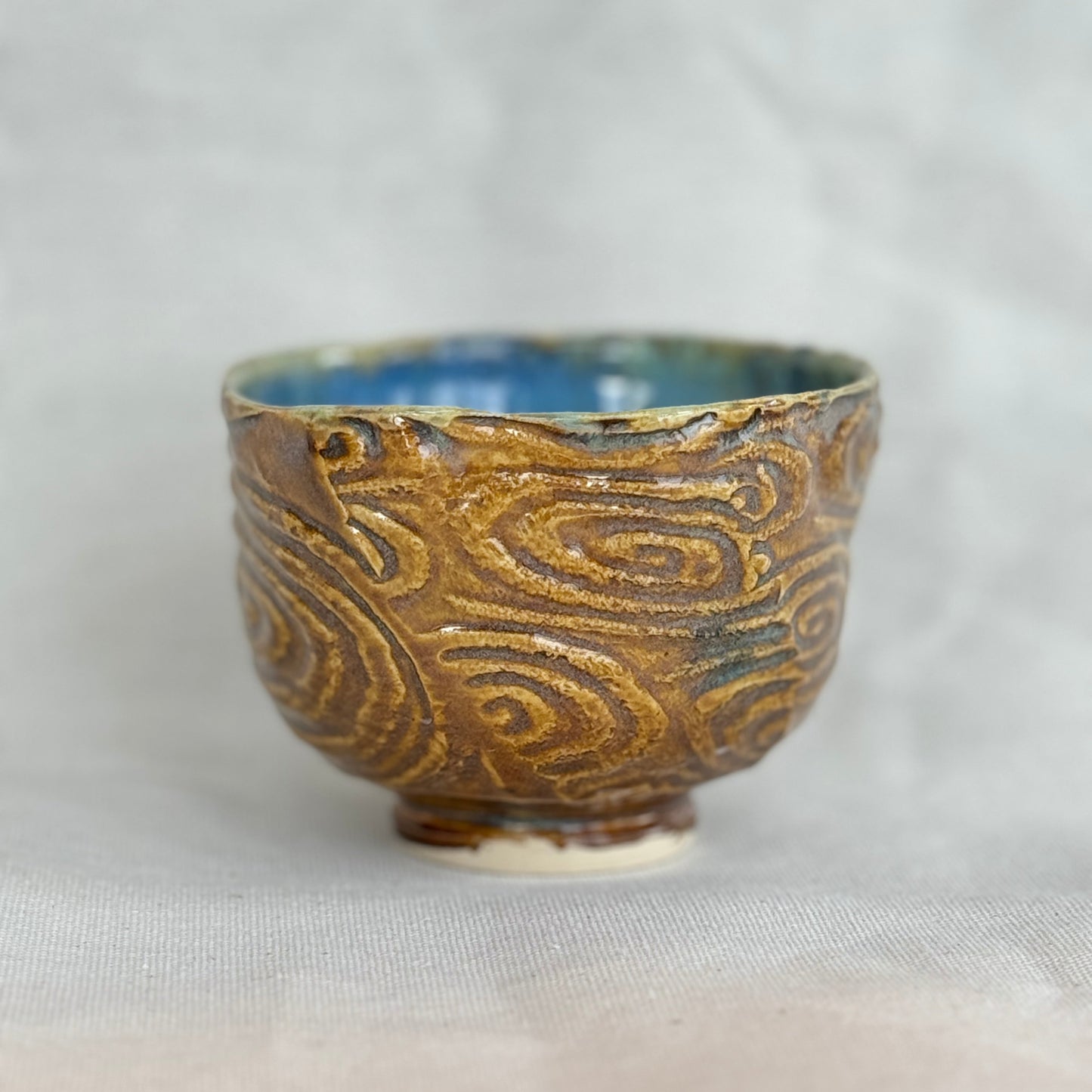 Ceramic cup with textured design on a light gray background