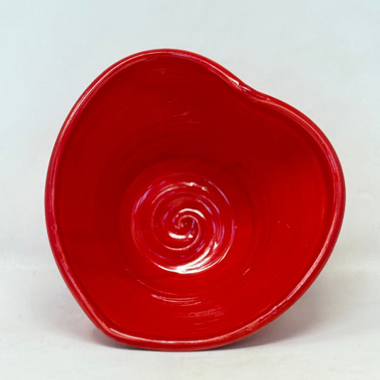 Red ceramic bowl with a spiral design on a white background