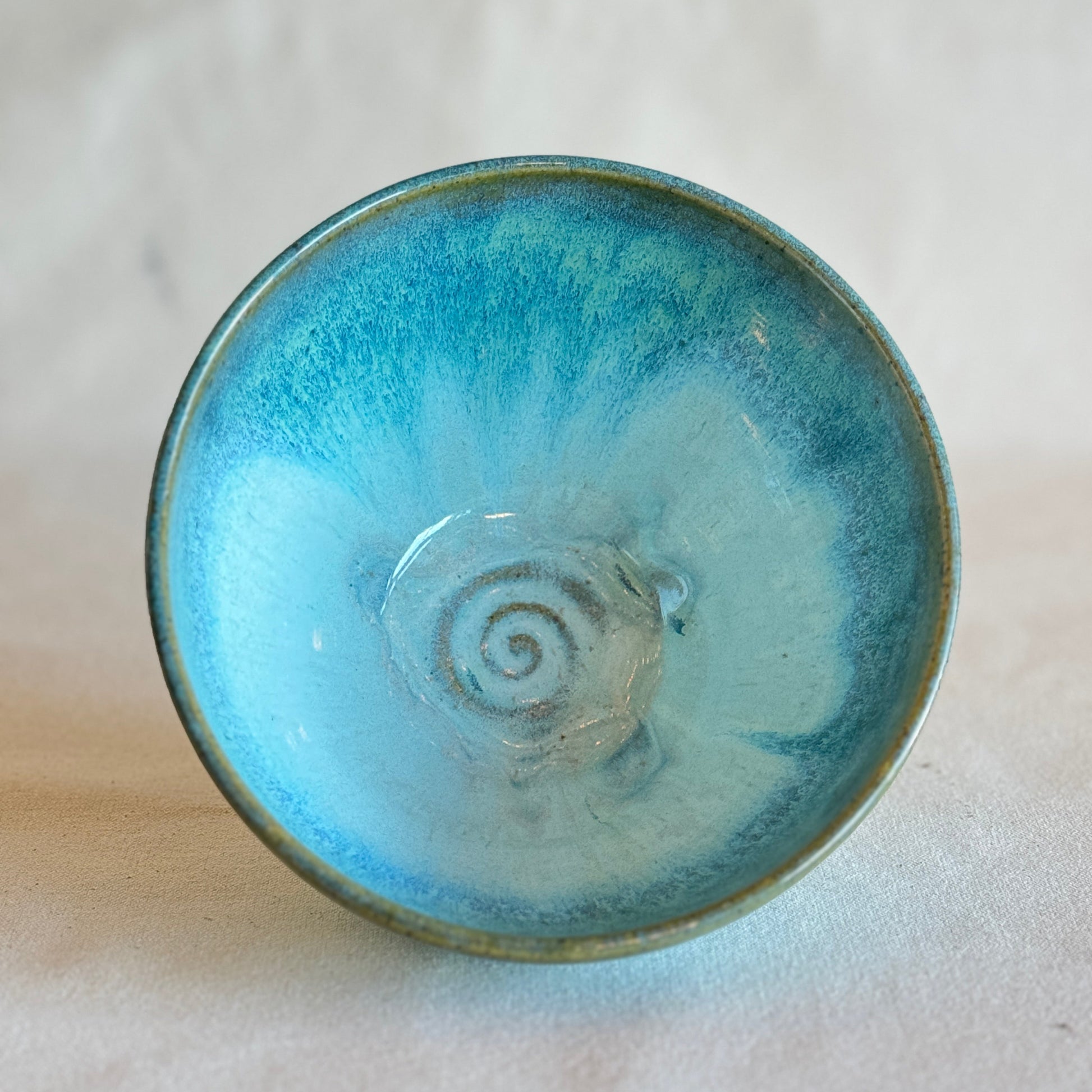 Blue ceramic bowl with a spiral design on a light background
