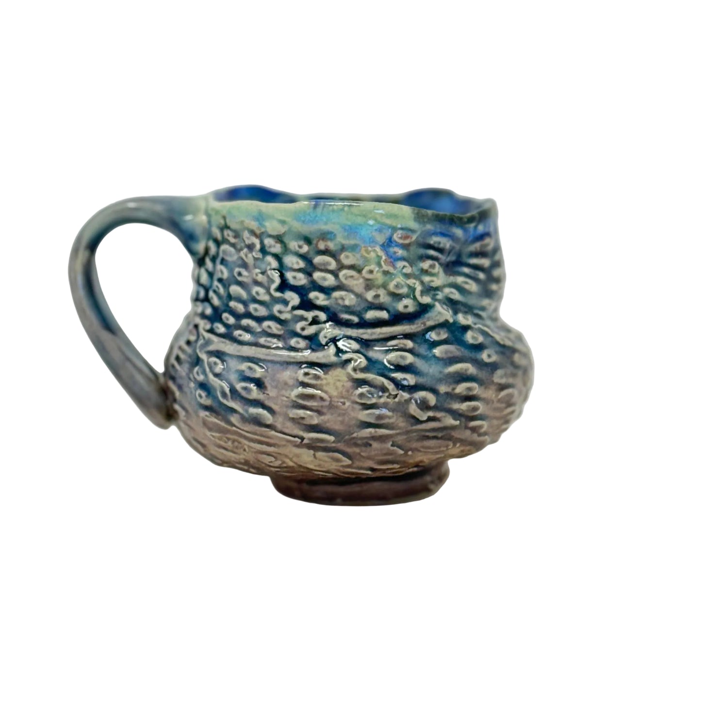 Handmade ceramic mug with blue and brown glaze on a white background