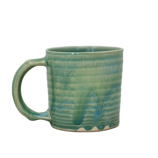 Green ceramic mug with textured surface on a light gray background