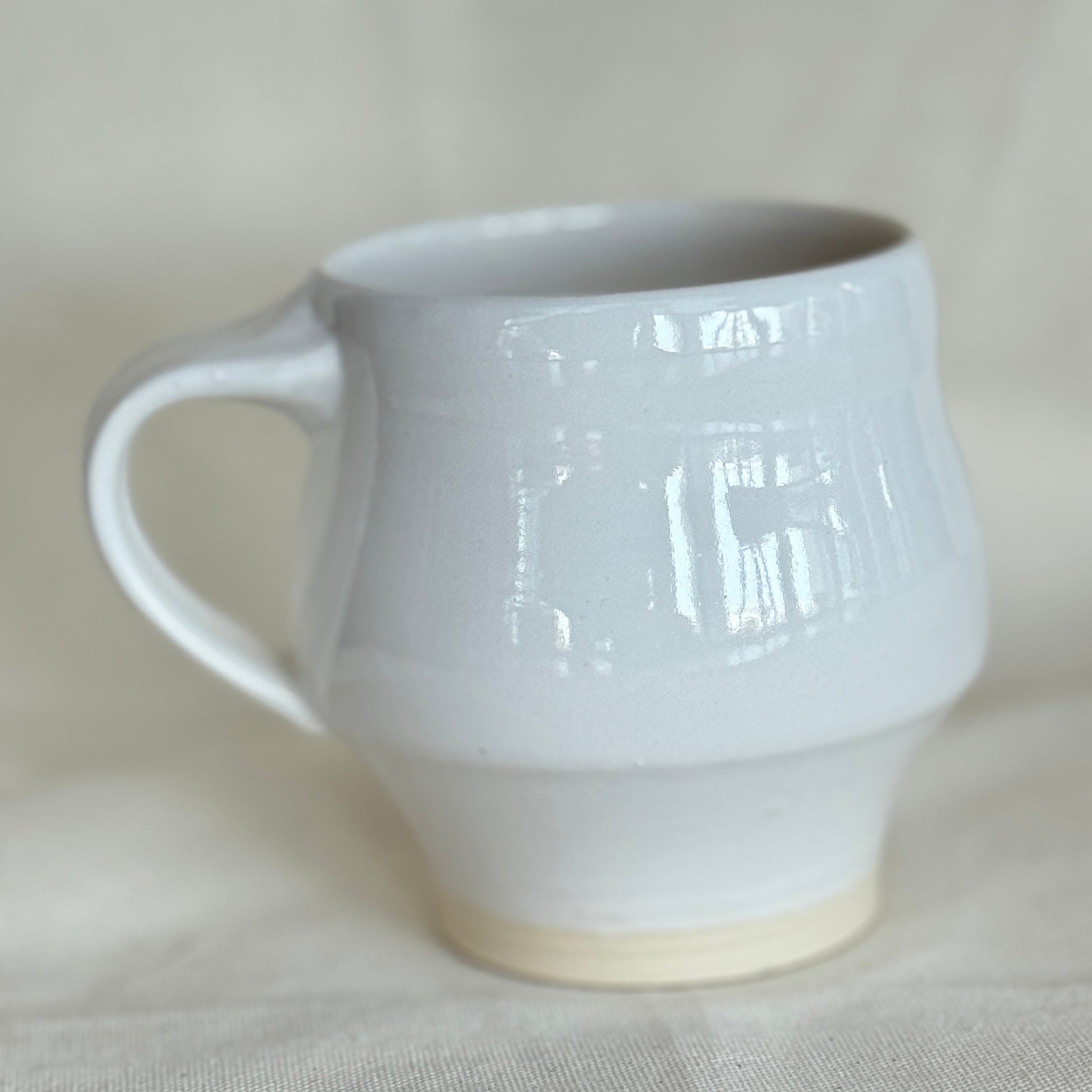 White ceramic mug on a light beige background