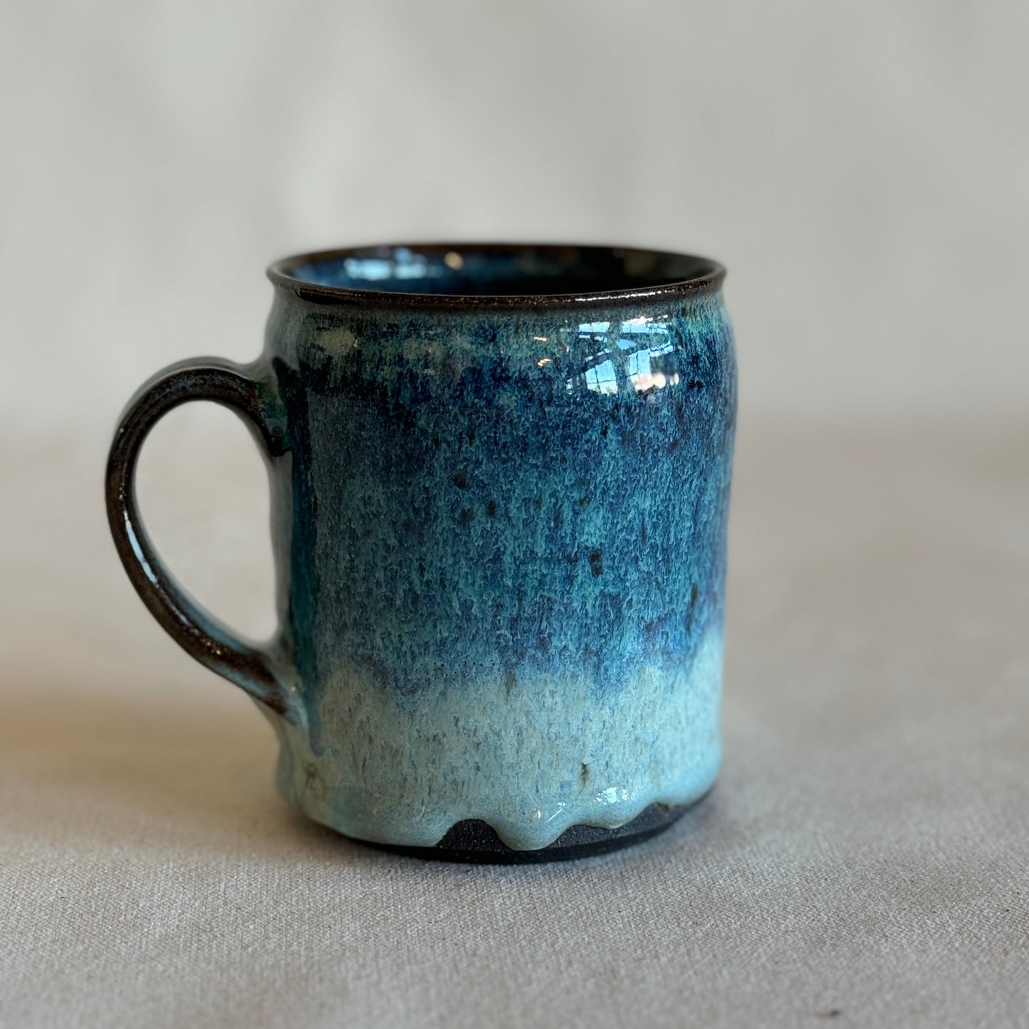 Blue and black ceramic mug on a beige background