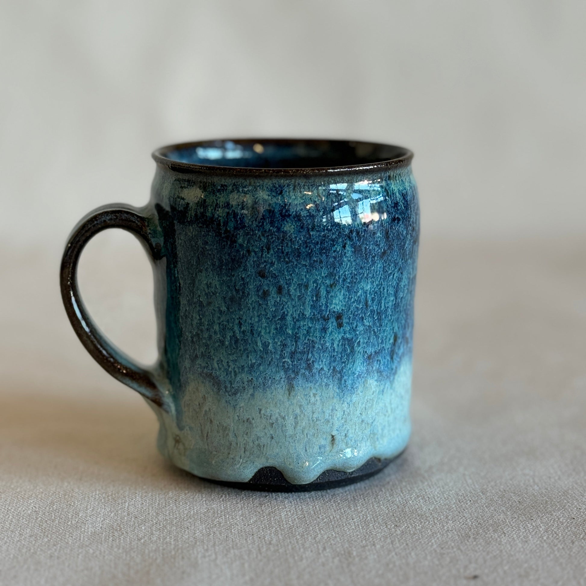 Blue and black ceramic mug on a beige background
