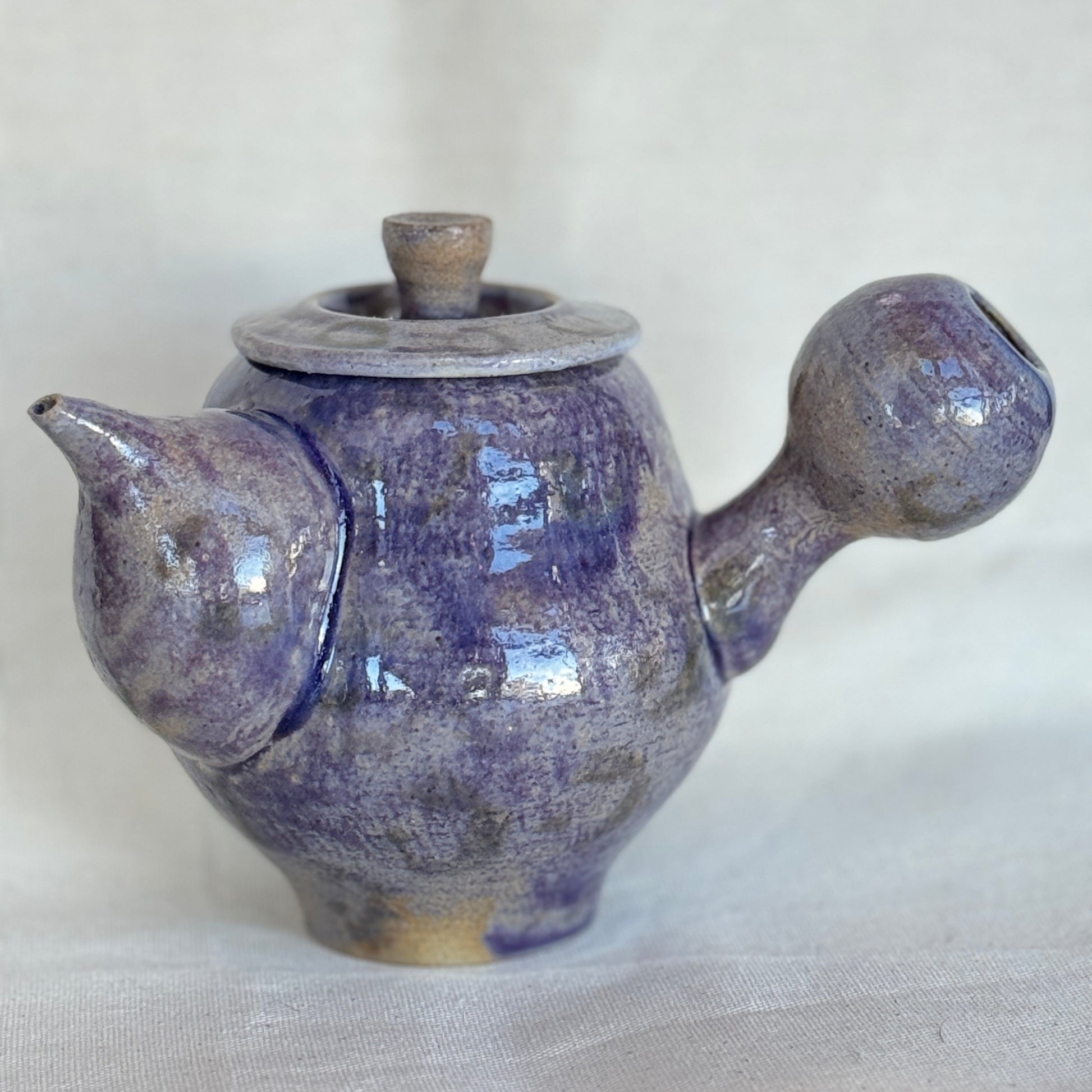 Ceramic teapot with a unique design on a white background