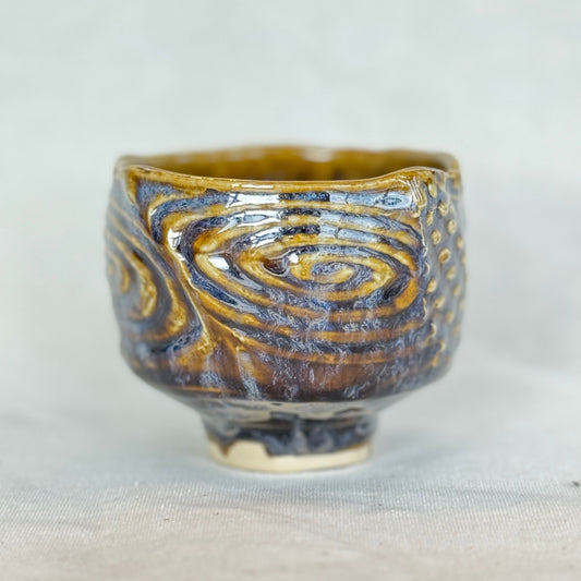 Ceramic cup with swirling pattern on a white background