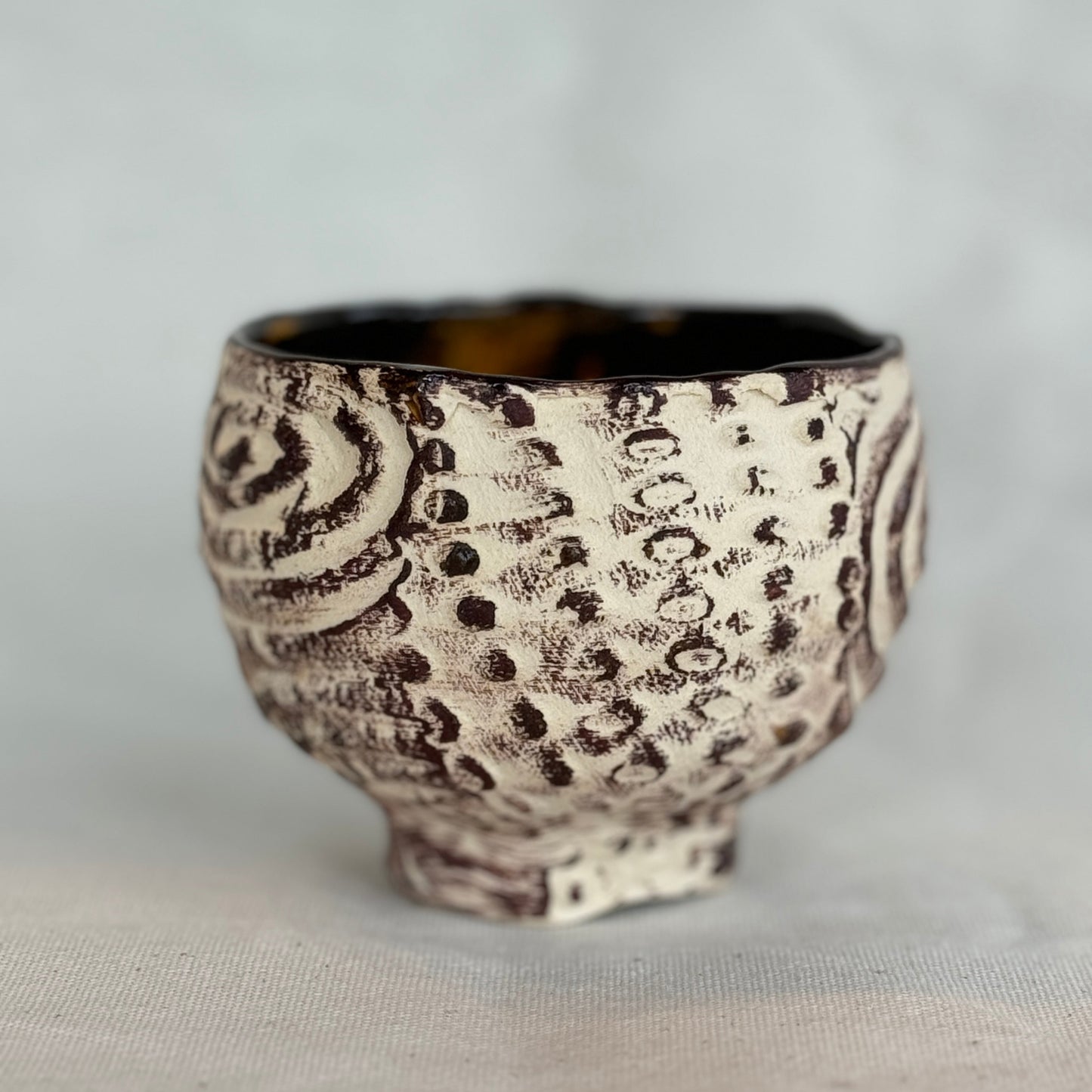 Ceramic cup with textured design on a light gray background