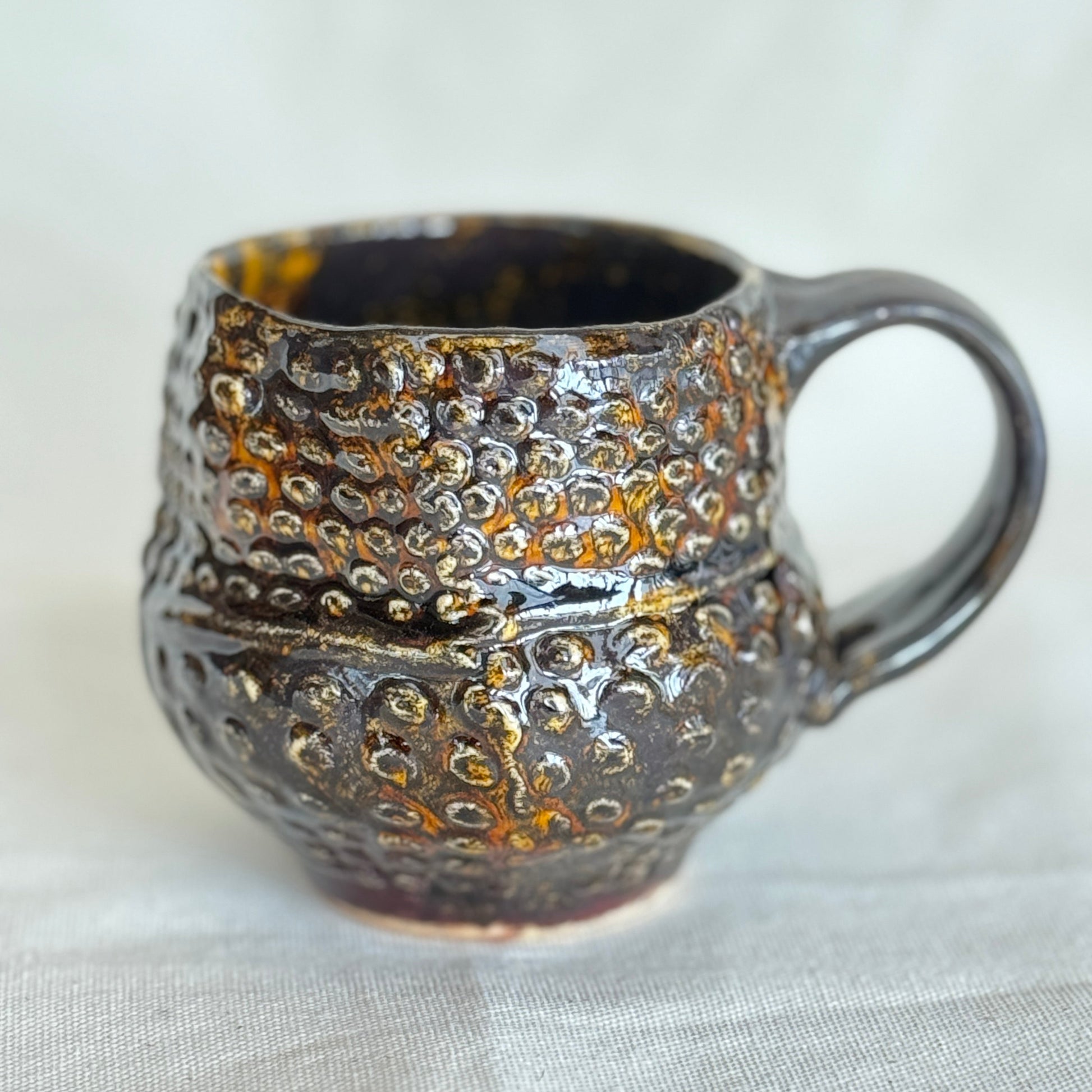Textured ceramic mug on a light fabric background