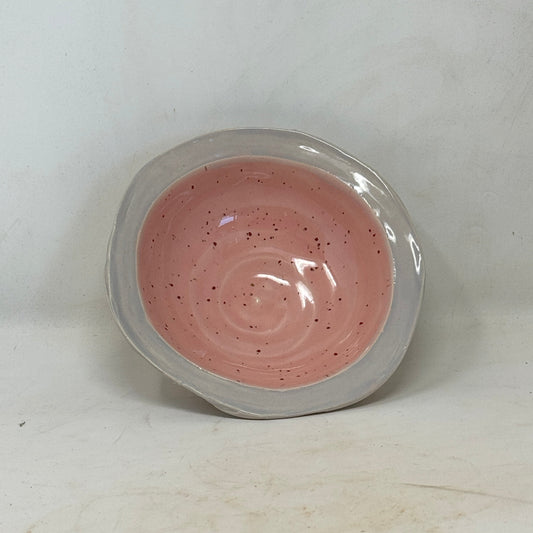 Pink swirled substance in a clear container on a white background