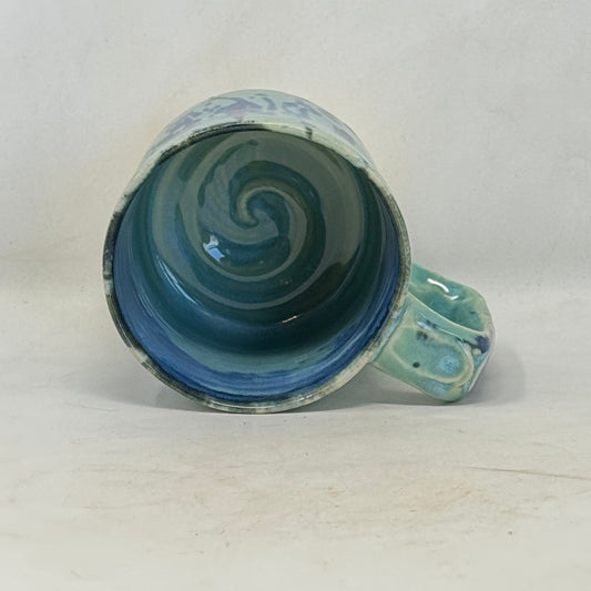 Ceramic mug with a blue spiral design on a white background
