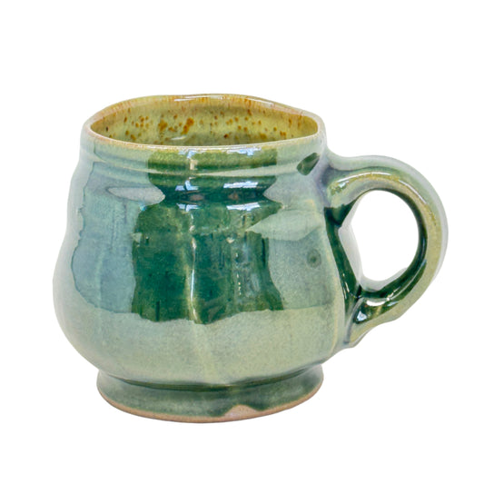 Green ceramic mug with a handle on a white background