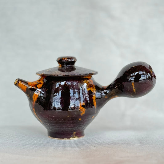 Brown ceramic teapot on a light gray background