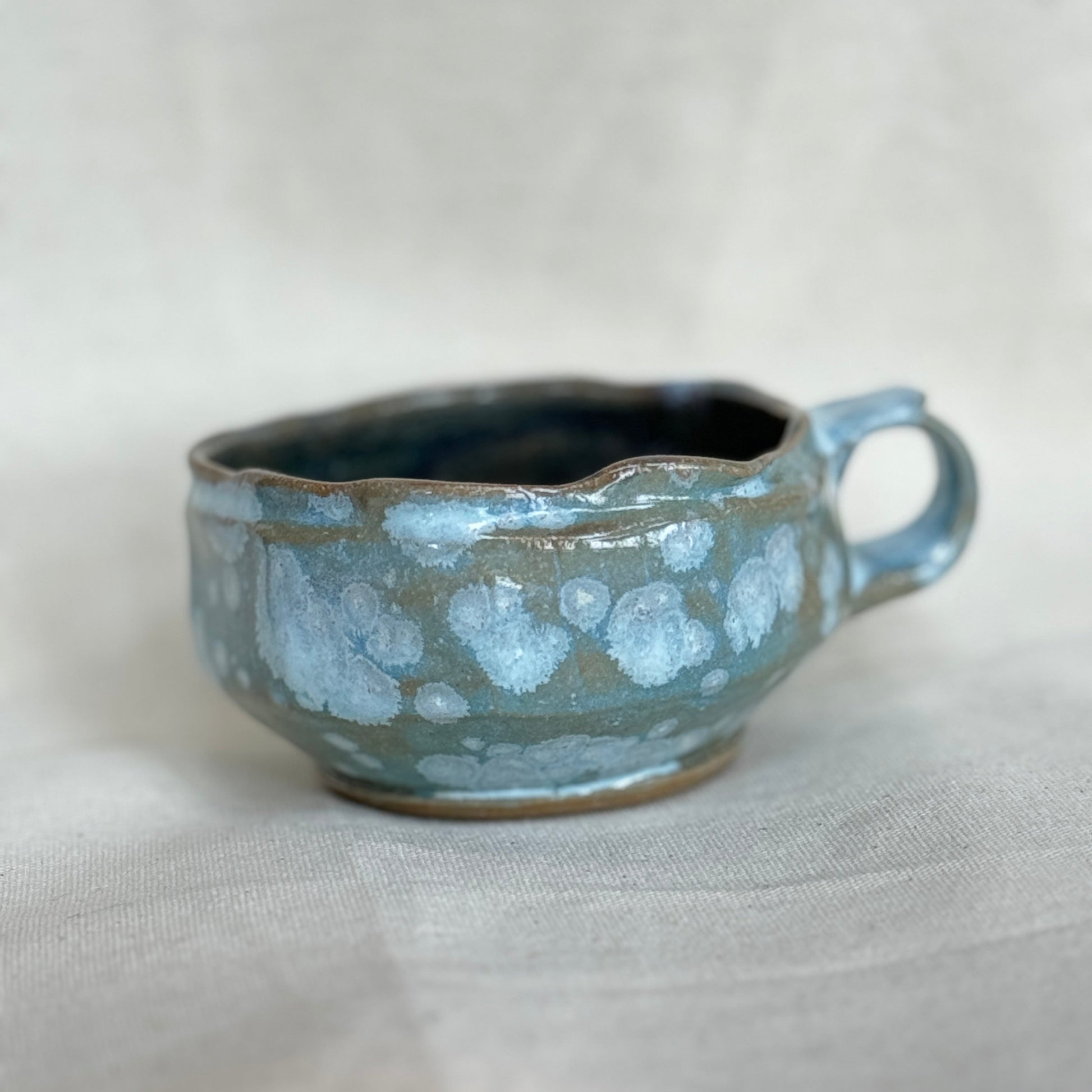 Ceramic cup with a textured surface on a light gray background