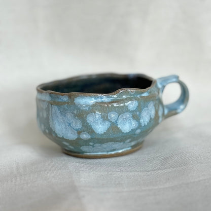 Ceramic cup with a textured surface on a light gray background