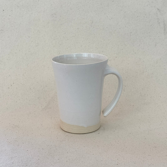 White ceramic mug on a textured beige surface
