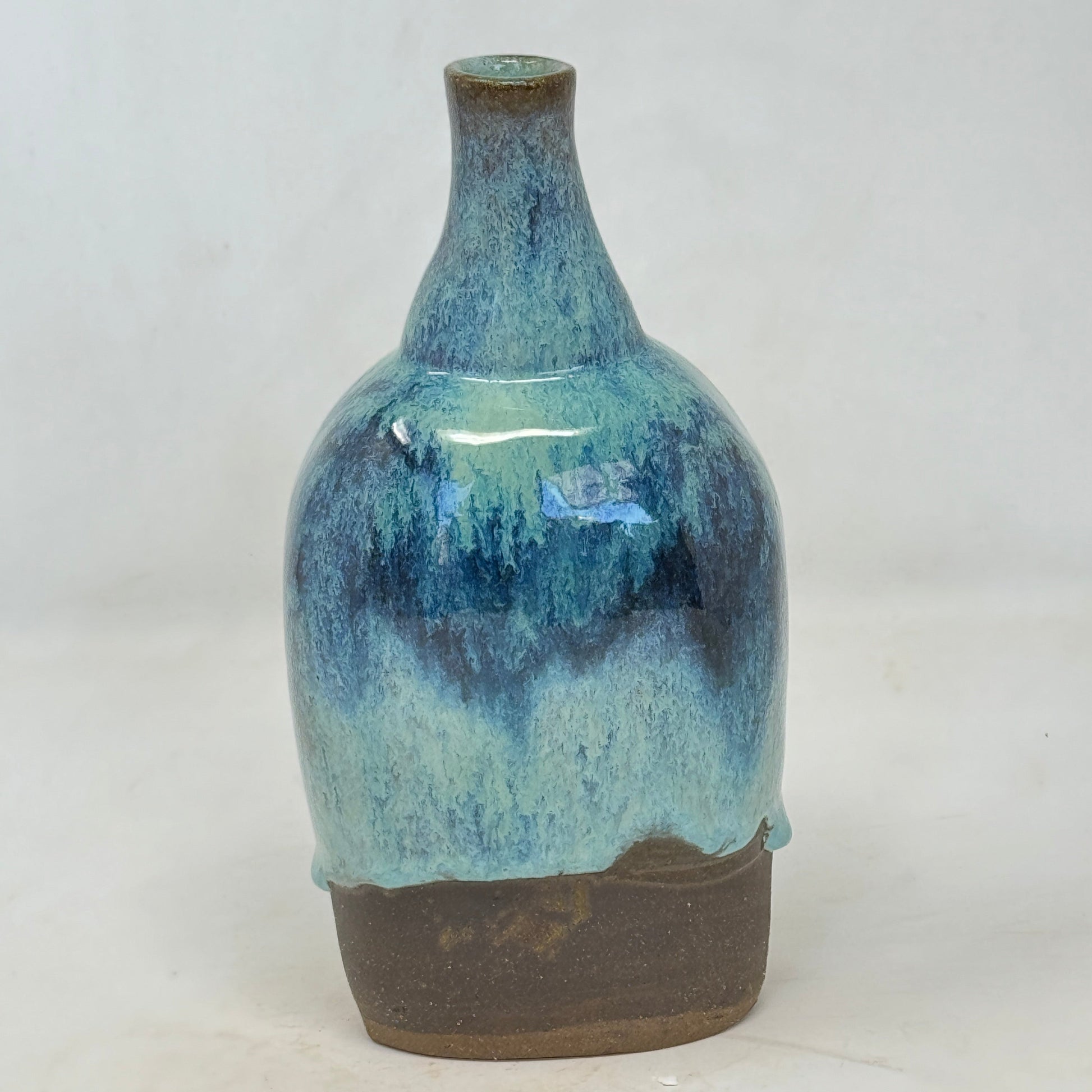 Ceramic vase with blue and brown glaze on a white background