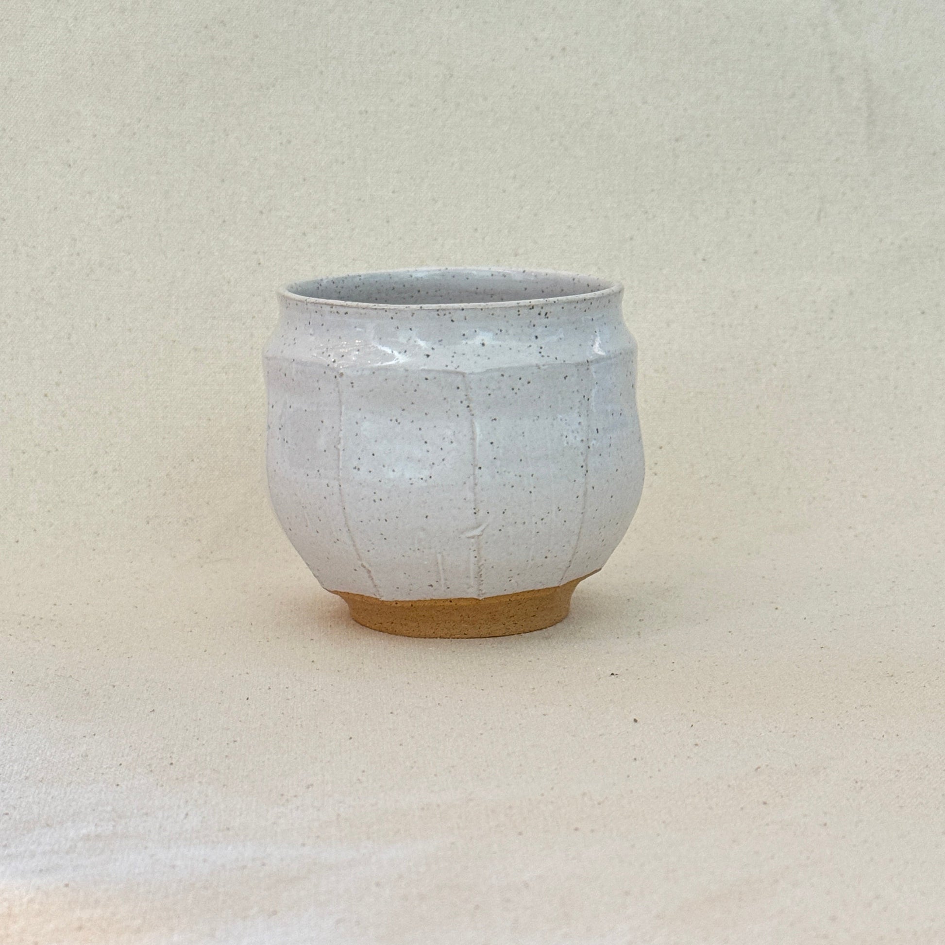 Small white ceramic bowl on a textured surface