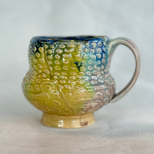 Ceramic mug with textured design on a white background