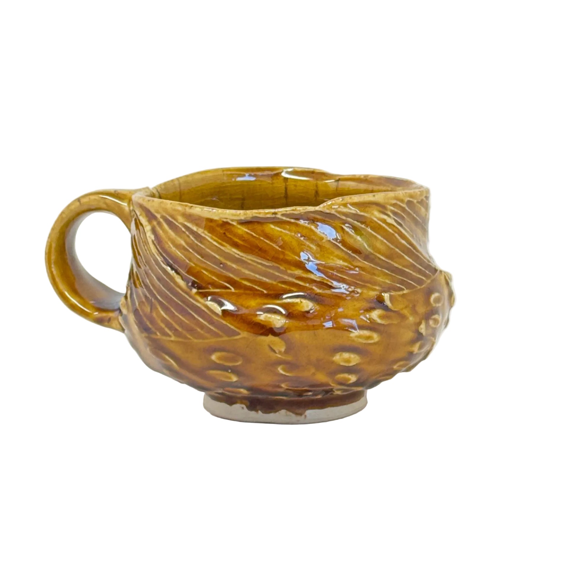 Decorative ceramic mug with leaf design on a white background