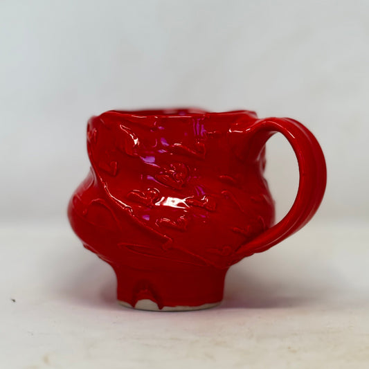 Red ceramic mug with handle on a white background