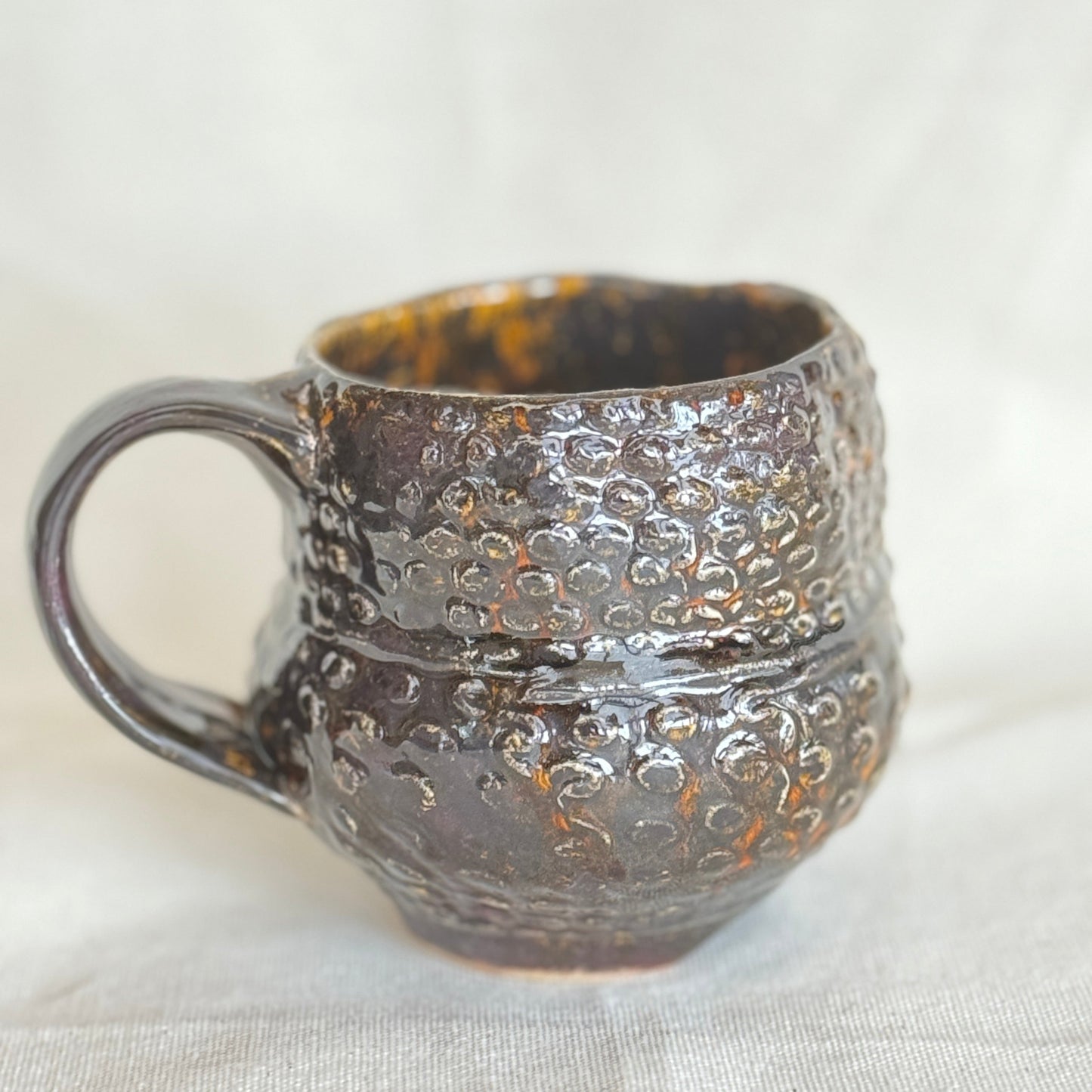 Textured ceramic mug on a light fabric background