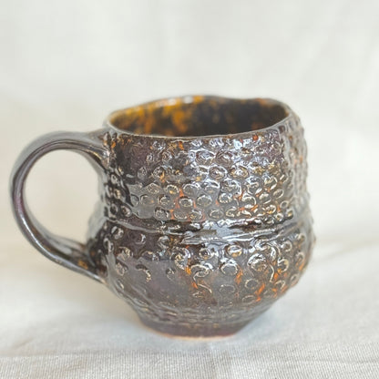 Textured ceramic mug on a light fabric background