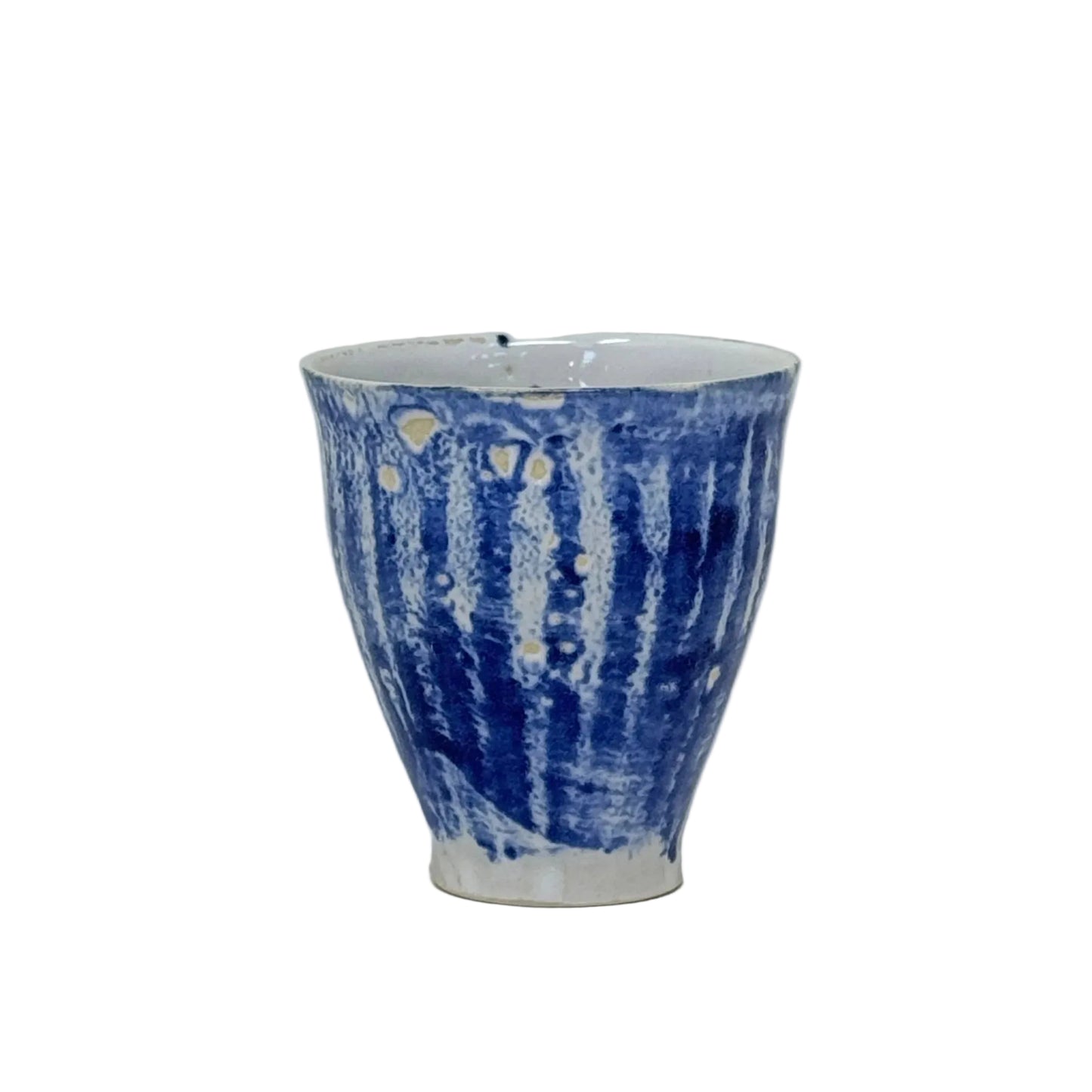 Ceramic cup with blue and white pattern on a light wooden surface