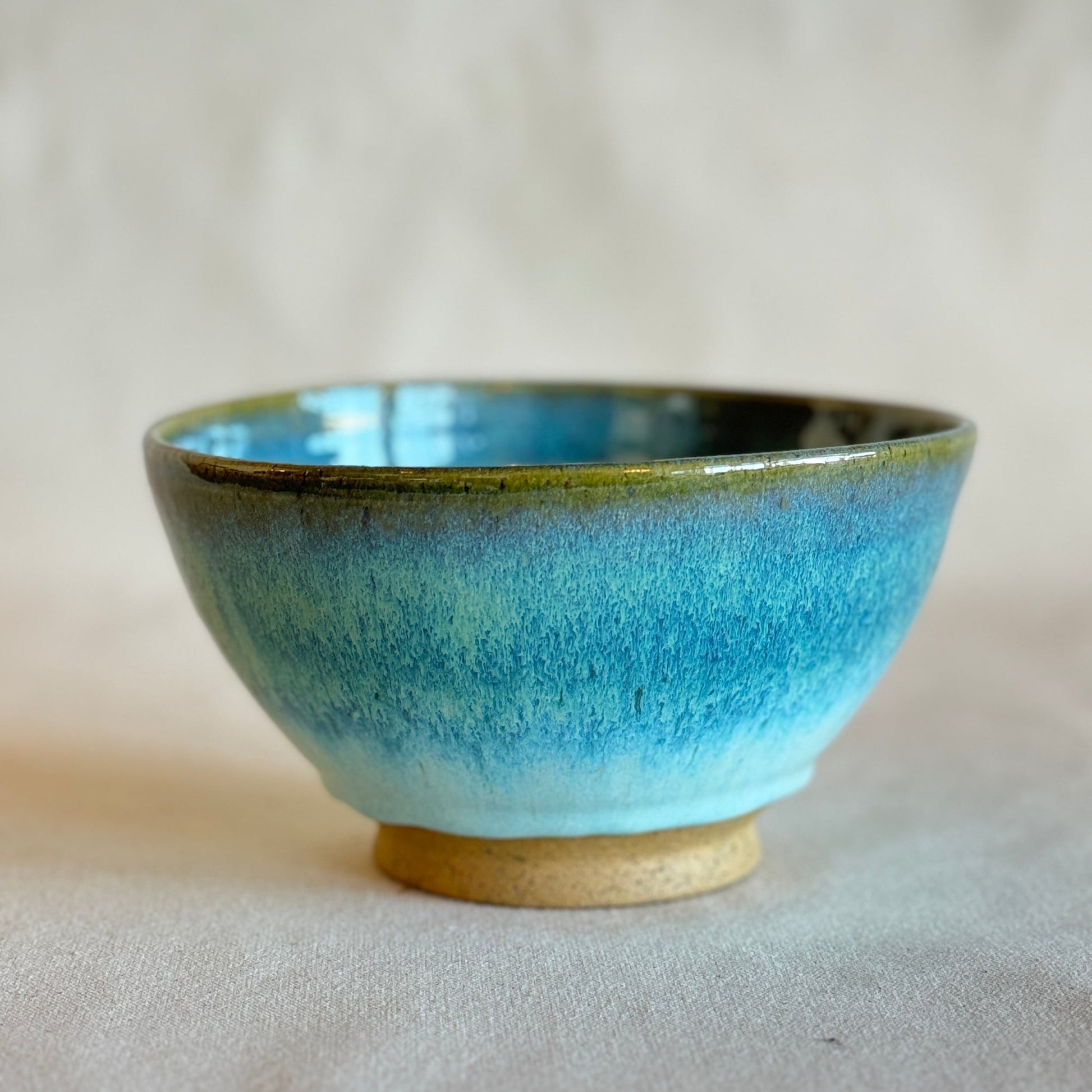 Ceramic bowl with blue glaze on a plain background
