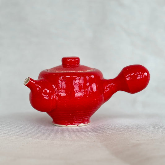 Red ceramic teapot on a white background