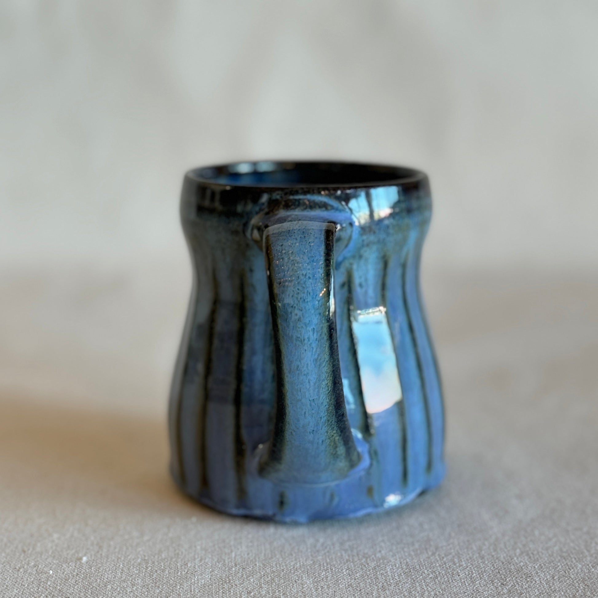 Blue ceramic mug with a handle on a gray background