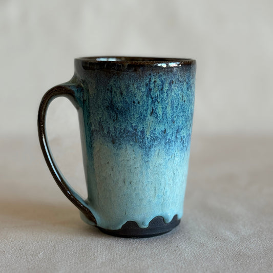 Blue and black ceramic mug on a light gray background