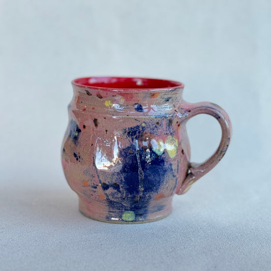 Ceramic mug with multicolored speckles on a light gray background