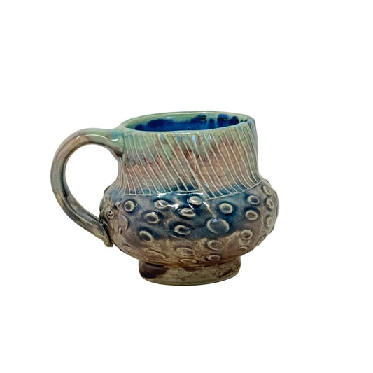 Ceramic cup with decorative design on a white background