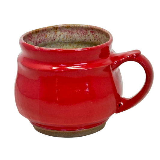 Red ceramic mug with a textured interior on a white background